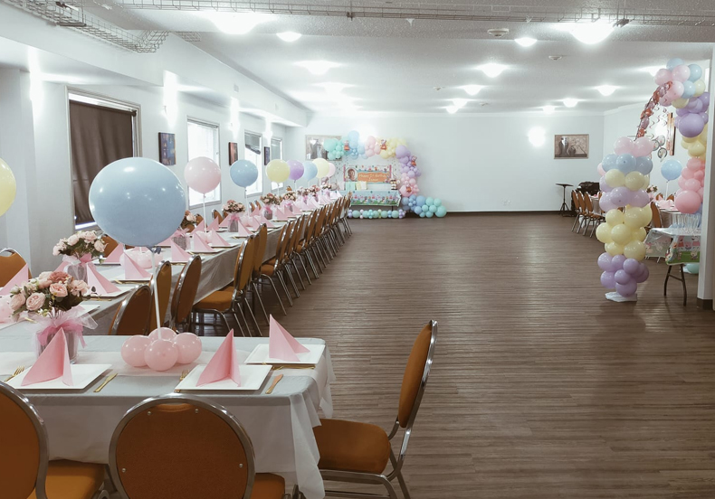 Banquet hall set for an event with long tables at Sunset Inn and Suites Sioux Lookout